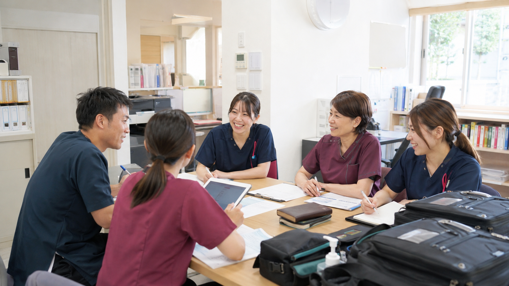 明るい事務所で打ち合わせをする訪問看護スタッフ
